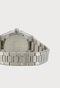 Orologio in acciaio inox argentato con quadrante rettangolare, cassa ottagonale e bracciale a maglie con segmenti alternativamente lucidi e opachi.