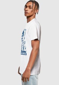 White cotton t-shirt featuring a blue graphic print of a basketball player and the text "Remarkable." Crew neck and short sleeves.