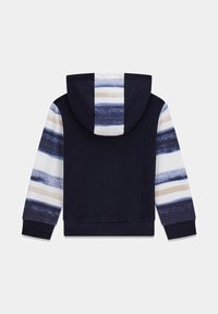 Sweat à capuche bleu marine avec un motif rayé beige, bleu et crème sur les manches. Comprend une poche kangourou et des poignets et ourlet côtelés.