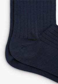 Marineblaue gerippte Socken mit glatter Textur und verstärktem Zehen- und Fersenbereich. Sie verfügen über ein klassisches Design mit vertikalen Rippungen über die gesamte Socke.