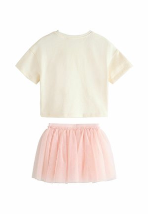 White cropped t-shirt made of cotton paired with a pink tulle skirt. The skirt has a gathered waistband and multiple layers for volume.
