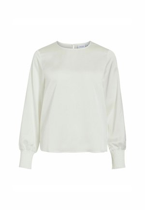 Blouse blanche à manches longues avec un col rond et des poignets smockés, présentée sur un fond blanc uni.