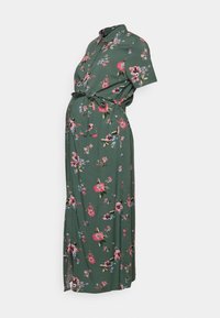 Abito floreale verde con design a bottoni, maniche corte e cintura da annodare; il tessuto ha una consistenza liscia con motivi di fiori rosa e blu.