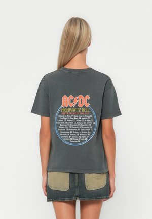Harmaa puuvillapaita, jossa on takana graafinen kuva, jossa on "AC/DC" -teksti, pyöreä muotoilu ja kiertuepaikat lueteltuna sinisen ja oranssin värisinä.