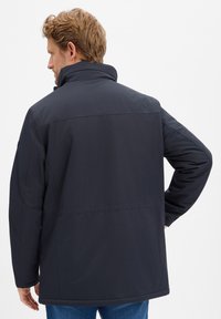 Ciemnoniebieska kurtka przeciwdeszczowa z wysokim kołnierzem i długimi rękawami, o gładkiej strukturze i minimalistycznym designie.