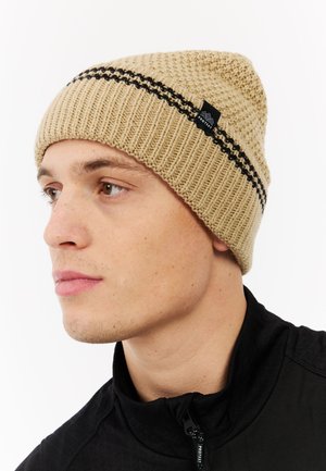 Knit beige beanie with black horizontal stripes and a small black logo tag. Ribbed texture; soft fabric; fitted design.