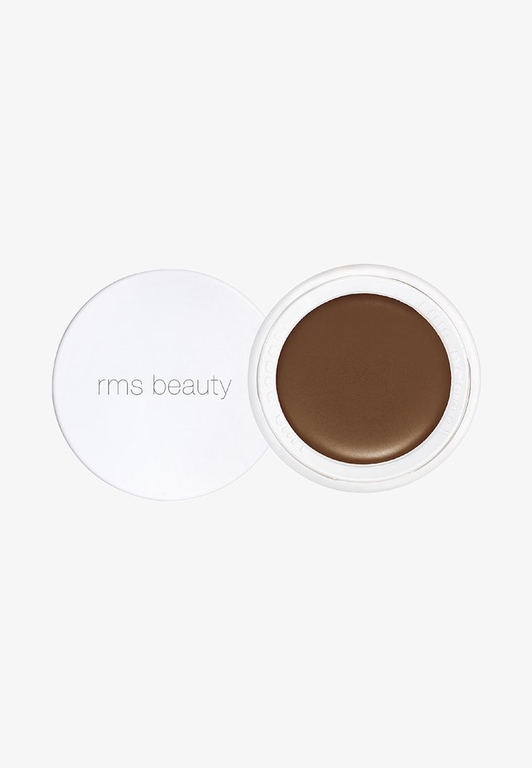 Crema RMS Beauty di tonalità marrone in un contenitore circolare bianco con una texture liscia e una finitura lucida, dotato di un coperchio rimovibile.