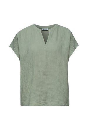 Blouse vert clair à manches courtes en tissu texturé, avec un col rond et une petite encoche en forme de V à l'avant.