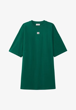 Zielony, oversize'owy t-shirt z krótkim rękawem, z małą naszywką z logo Calvin Klein, umieszczoną centralnie poniżej dekoltu.