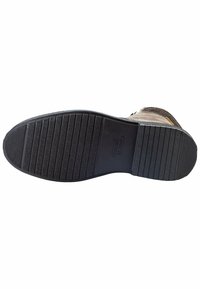 Braunes Wildleder-Schuh mit Gummisohle, ausgestattet mit einem strukturierten Profilmuster und einem Logo auf der Sohle, entwickelt für Langlebigkeit und Grip.