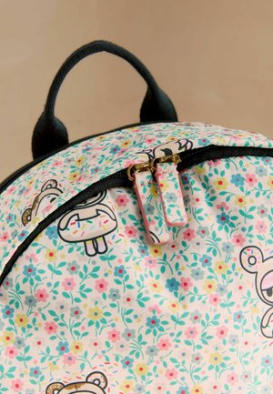 Backpack with black handle and zipper, featuring pastel floral pattern and cartoon bear faces holding sprinkled donuts.