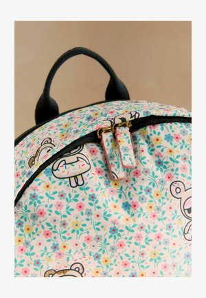 Backpack with black handle and zipper, featuring pastel floral pattern and cartoon bear faces holding sprinkled donuts.
