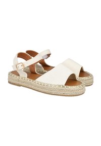 Sandalias espadrilles blancas con amplias correas cruzadas, suela de yute natural y detalle de hebilla ajustable en el tobillo. Textura suave, diseño de punta abierta.