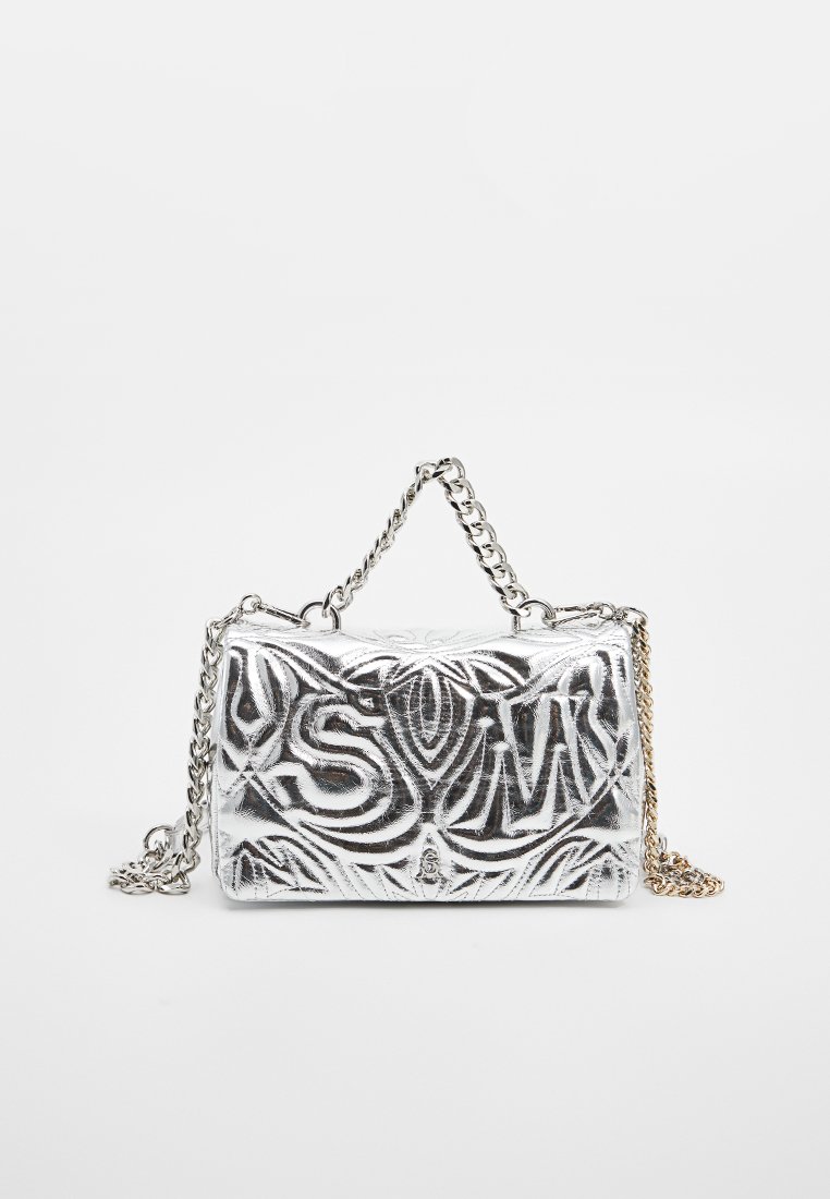 Pequeño bolso metálico plateado con un patrón ornamental en relieve y correa de cadena plateada sobre un fondo blanco liso.