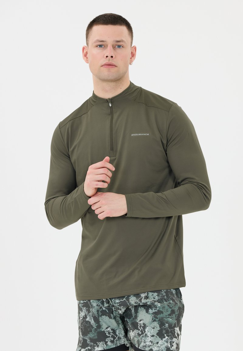 Olivgrünes langärmeliges Zip-Up-Oberteil mit hohem Kragen und subtilen Logodetails. Glattes, leichtes Material mit figurbetontem Schnitt.