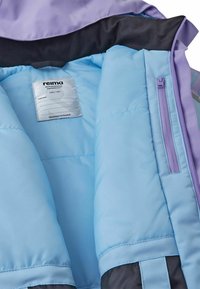 Wnętrze ocieplanej kurtki ma jasnoniebieską podszewkę, fioletowe akcenty oraz metkę. Posiada boczną kieszeń na zamek dla dodatkowej funkcjonalności.