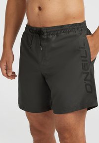 Shorts de bain noirs en tissu léger, dotés d'une taille élastique avec cordon de serrage, et d'un logo "O'Neill" audacieux sur le côté.