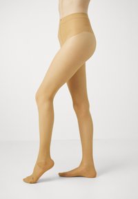 Knee-high nude tights with a smooth, sheer texture, high waistband, and reinforced toe area, designed for comfort and a natural look.