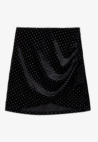 Jupe mini en velours noir avec un design drapé, ornée de pois blancs, offrant une texture lisse et une silhouette fluide.