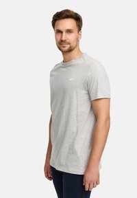 Grijze katoenen t-shirt met een ronde hals en korte mouwen; heeft een klein wit logo "JEFF" op de borst; gladde textuur.