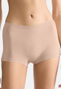 Beżowe, bezszwowe spodenki wykonane z miękkiej, elastycznej tkaniny. Posiadają klasyczne dopasowanie z gładkim pasem i bez widocznych szwów.