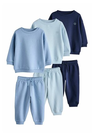 Drei Sets von Kinder-Sweatshirts und Hosen in Hellblau, Blassblau und Marineblau mit kleinen Smileys auf den Oberteilen.