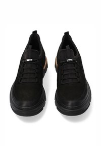 Czarne zamszowe sneakersy z gumową podeszwą, z okrągłym noskiem, elastycznymi sznurówkami i teksturowanym brązowym akcentem po boku.