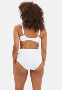 Bas de bikini blanc taille haute assorti à un bralette. Les deux pièces sont dotées d'un tissu lisse et de bretelles réglables avec des accents circulaires.