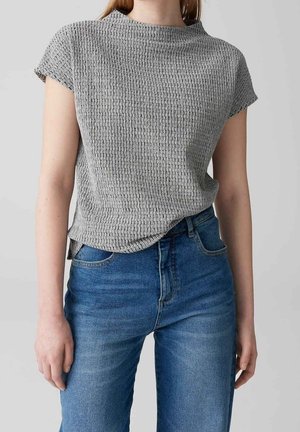 Grå textured kortærmet top med rund halsudskæring, parret med højtaljede blå denim jeans med klassisk fem-lomme stil.