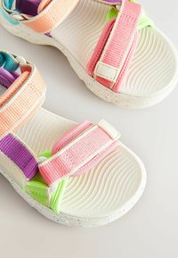 Farebné sandále s viacerými popruhmi v ružovej, fialovej a zelenej farbe, s textúrovanou bielou podrážkou a bodkovaným akcentom pre lepšiu priľnavosť.
