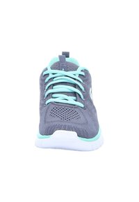 Baskets de sport grises avec une tige en maille, des lacets turquoise et une semelle blanche. La vue de face montre un design perforé et un col rembourré.