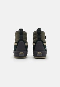 Zapatillas altas con tela verde y gris, cuellos acolchados, refuerzo en el talón y logo en la parte posterior. Presenta tiradores en bucle para facilitar el calzado.