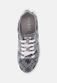 Pelēki kanvas kedu ar baltiem šņorēm, ar tumši zilām rakstām, logotipa rotājumiem sānos un acs caurumiem, kā arī gumijas zoli.