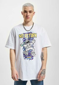 Hvid bomulds T-shirt med et farverigt astronautgrafik og teksten "NO RETURN" i fed lilla og gul, afslappet oversized design.