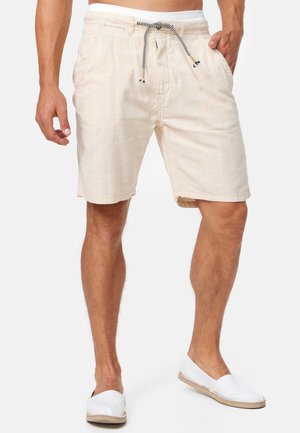 Shorts à carreaux beiges en tissu léger, dotés d'une taille élastique avec cordon de serrage et de poches latérales.