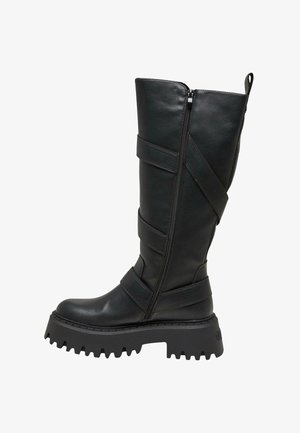 Bota negra de cuero hasta la rodilla con suela gruesa, que presenta múltiples correas horizontales y un cierre con cremallera en el lateral.