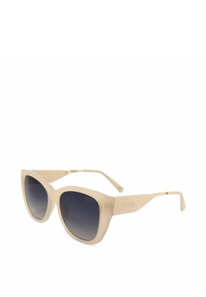 Occhiali da sole a gatta color crema con lenti sfumate scure e logo GUESS sulle aste.