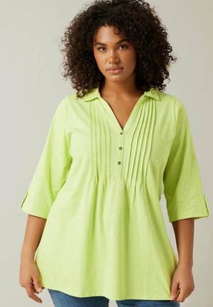Lichtgroene blouse met lange mouwen, plooien en een V-hals, met een knoopdetail. Zacht materiaal en ontspannen pasvorm, geschikt voor casual draag.