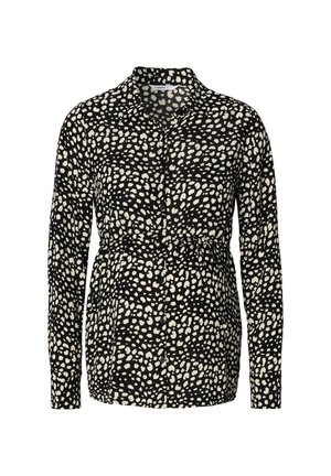 Camisa negra de botones con mangas largas, presenta un patrón abstracto de puntos blancos y una cintura elástica para un ajuste relajado.