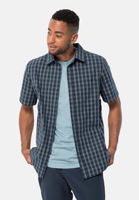 Korte mouw gecontroleerd overhemd in marineblauw en lichtblauw, met een kraag en knoopsluiting, gelaagd over een lichtblauwe ronde hals t-shirt.