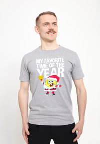 Šedé bavlněné tričko s barevným grafikou karikatury postavy v obleku Santa Clause s textem "MOJE NEJOBLÍBENĚJŠÍ OBDOBÍ V ROCE."