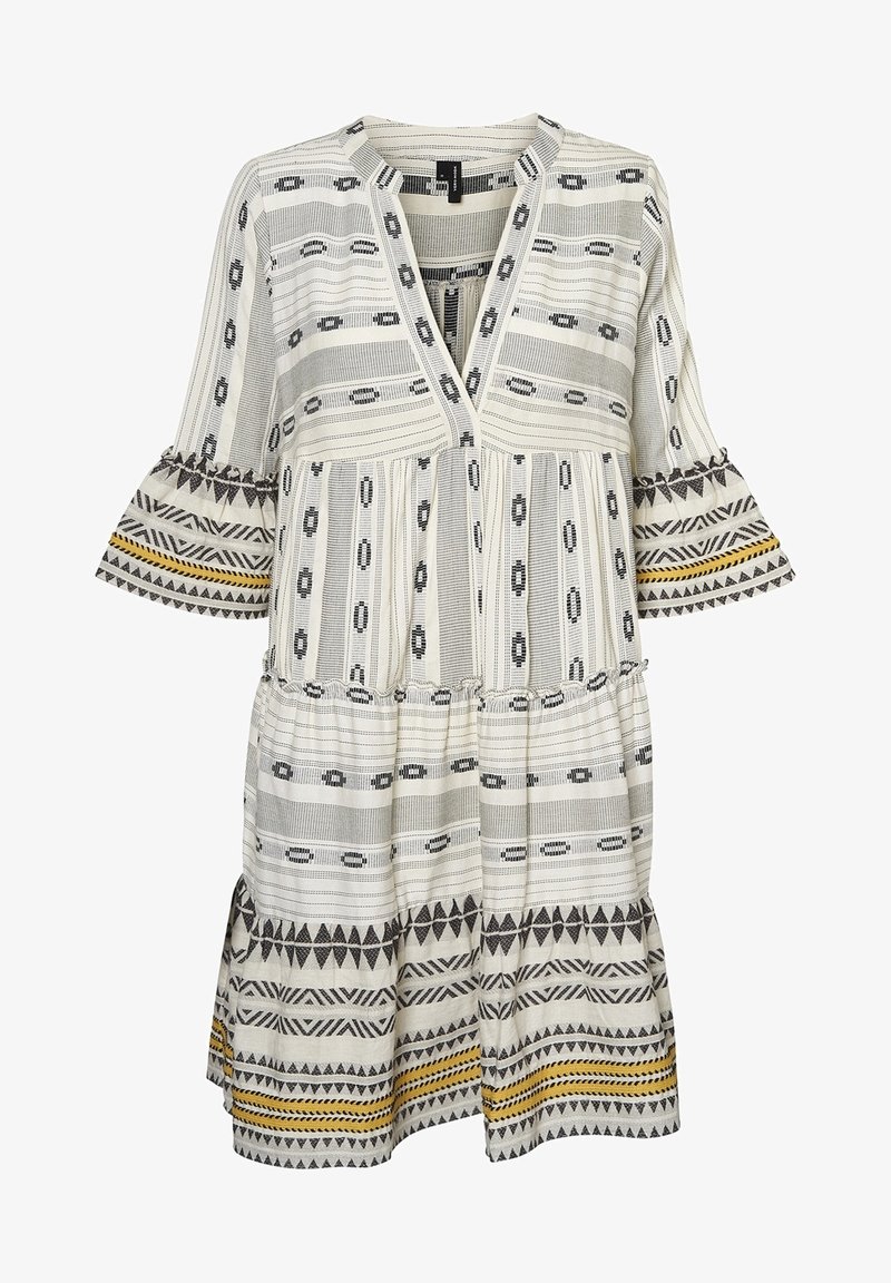 Robe blanche ample avec motifs géométriques noirs et accents jaunes, manches cloche trois-quarts, et col en V avec des détails de jupe plissée.