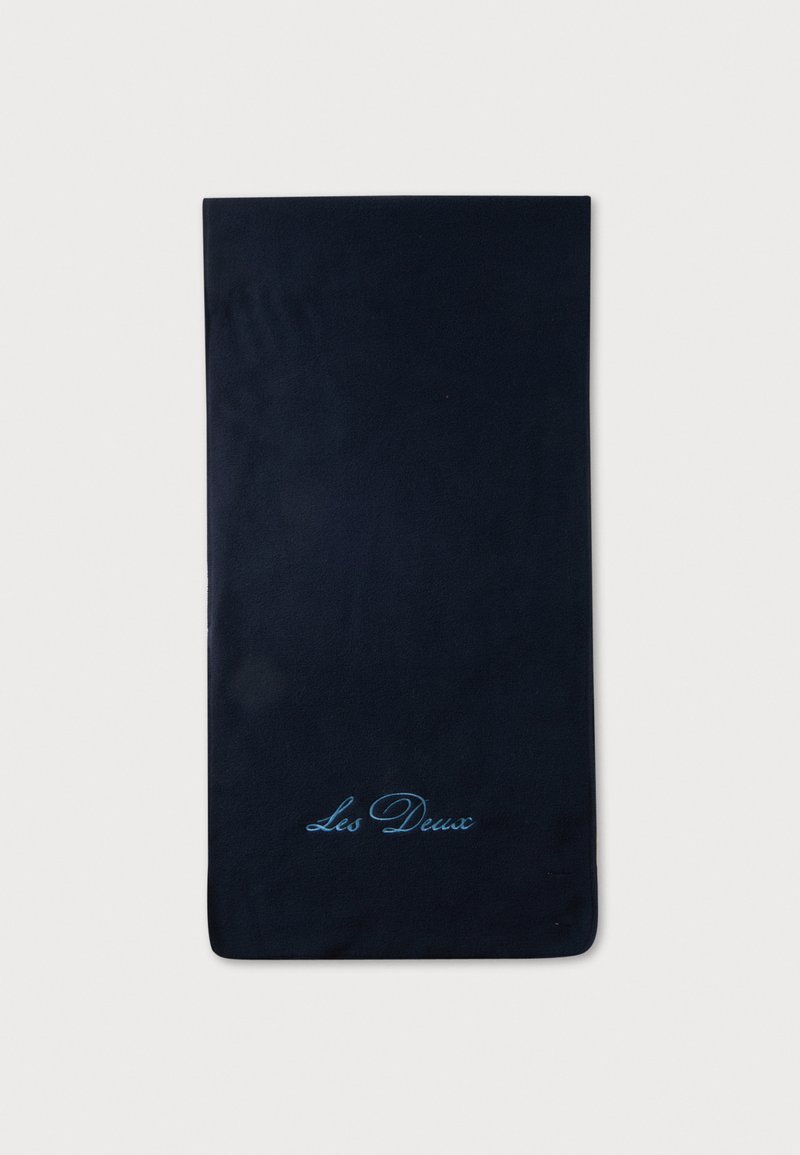 Tissu rectangulaire noir avec un texte cursif bleu clair "Les Deux" près d’un bord sur un fond blanc uni.