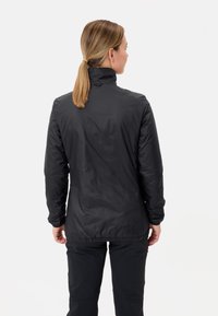 Giacca nera impermeabile con colletto alto, vita elastica e maniche lunghe. Texture liscia e design semplice, mostrata dal retro.