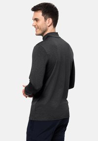 Dunkelgraues Langarm-Polohemd mit Kragen, das eine glatte Textur und eine lockere Passform aufweist. Die R�ückansicht zeigt die Schlichtheit des Designs.