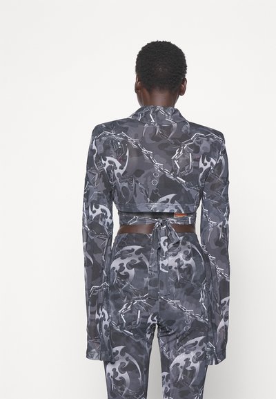 Μαύρο και γκρι σχέδιο κοντό σακάκι με μακριά μανίκια, που διαθέτει ζώνη με κόμπο και μοτίβα αλυσίδας, φτιαγμένο από λεία, ελαστική ύφασμα.