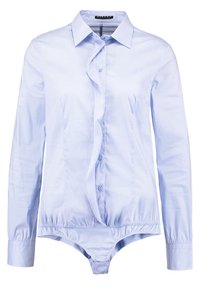 Ljusblå långärmad skjorta med knäppning och volangdesign framtill. Tillverkad av ett smidigt tyg, har en figursydd bodysuitbas och knappstängningar.