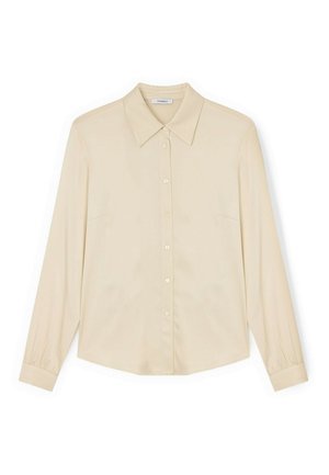 Camisa beige de manga larga con botones, cuello puntiagudo y puños abotonados, colocada plana sobre un fondo blanco.
