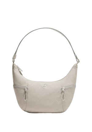 Jasnobeżowa torba na ramię z szerokim paskiem, dwoma poziomymi zamykanymi kieszeniami z przodu oraz małym okrągłym logo umieszczonym centralnie na tkaninie.