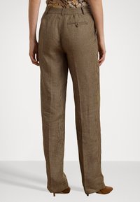 Pantalons à carreaux marron et noir avec un design droit, poches avant et arrière, et fermeture éclair. Fabriqués en tissu texturé.